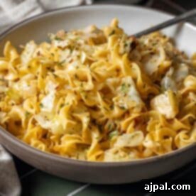 A bowl of cooked egg noodles tossed with sautéed cabbage and garnished with fresh chopped herbs creates a classic cabbage and noodles dish.