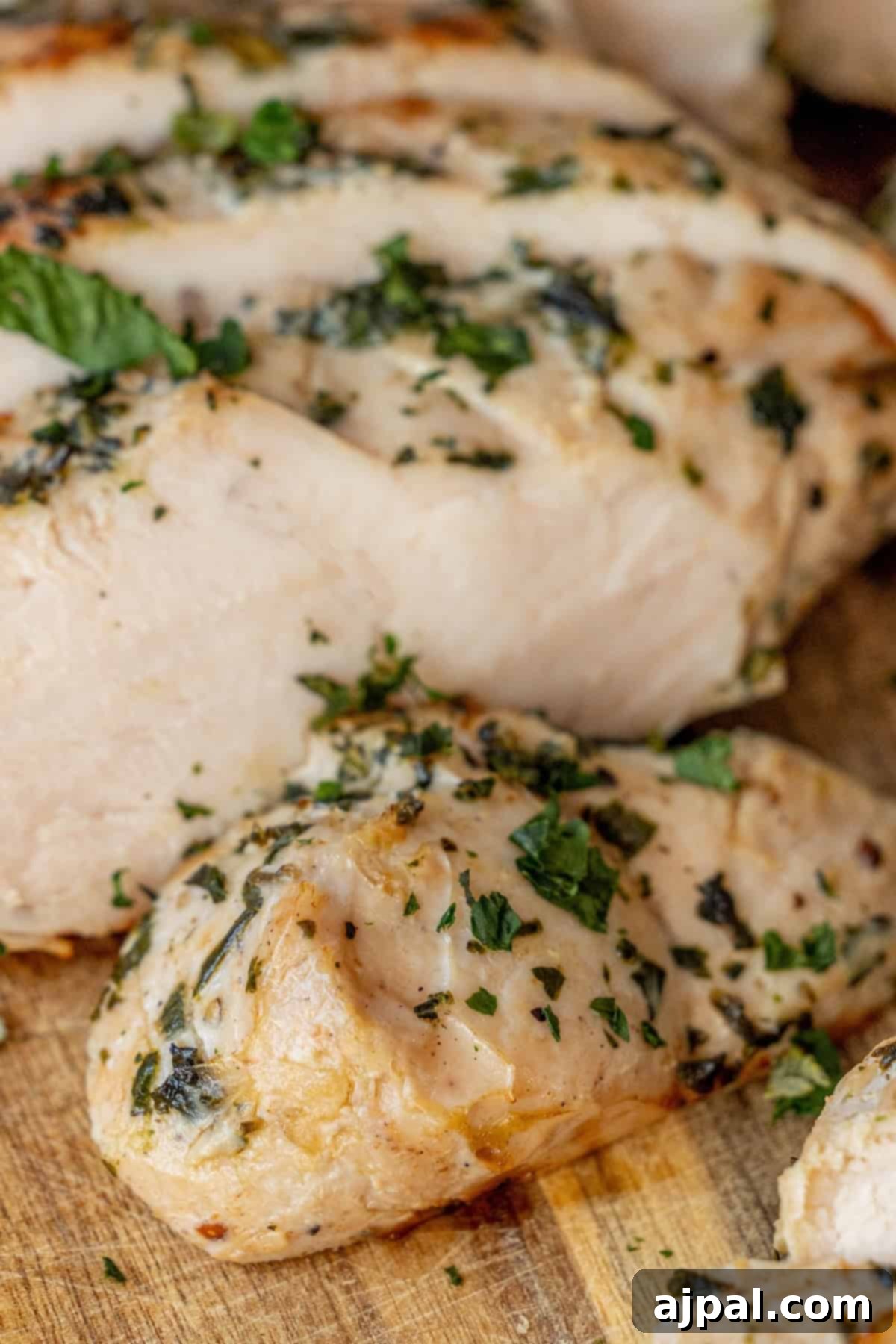 Sliced grilled chicken breast garnished with herbs, reminiscent of an easy turkey recipe.