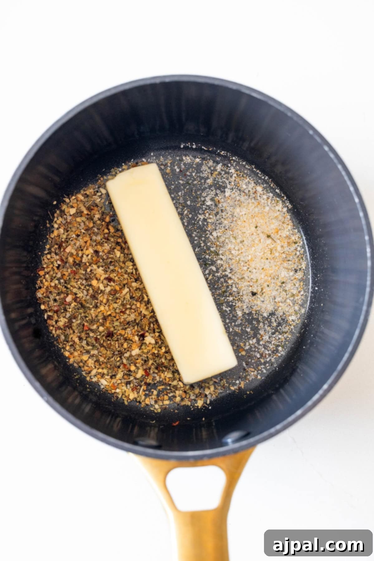A saucepan with butter, herbs, and spices.