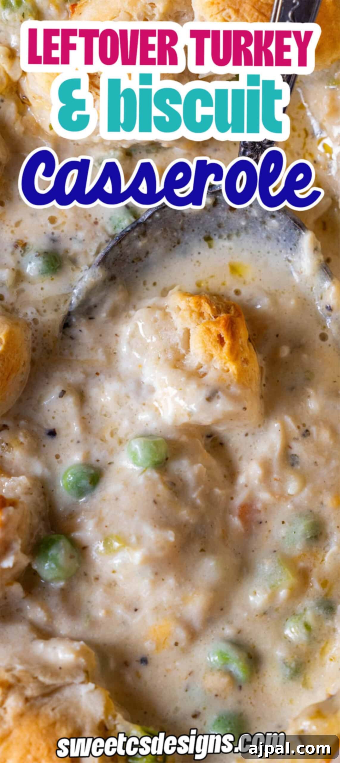 Close-up of a biscuit casserole made with leftover turkey, peas, and creamy sauce. A spoon scoops the delicious mixture.