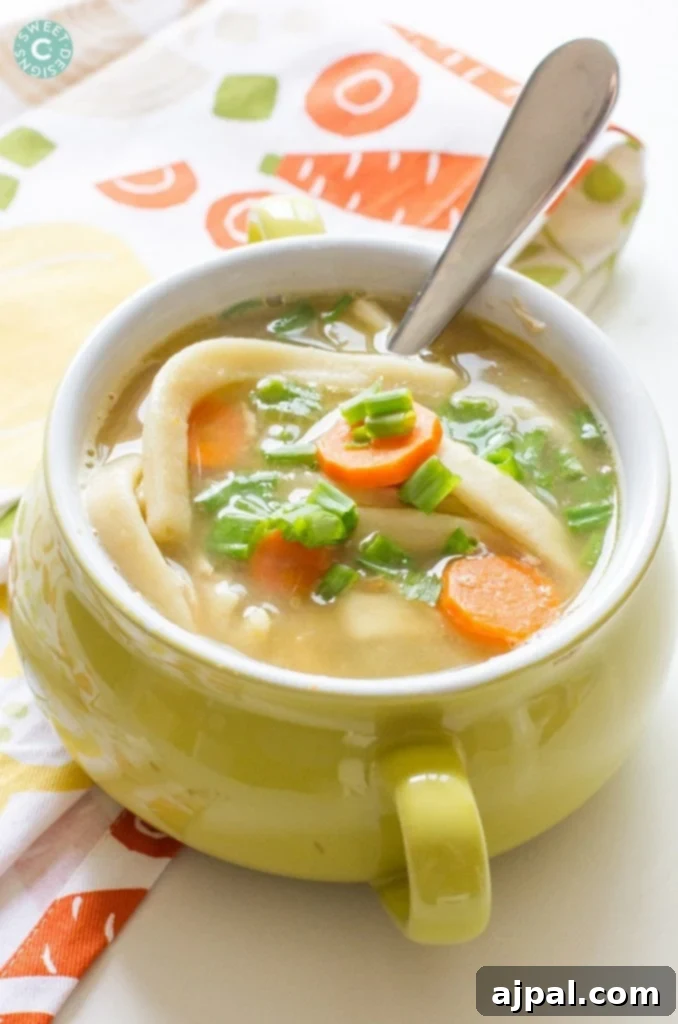 Easy Homemade Chicken Noodle Soup 3 bowl of soup with noodles, carrots, and green onions on it