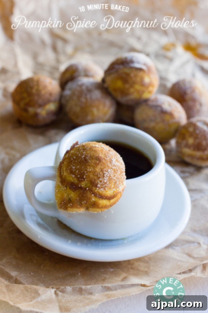 A comforting scene with a steaming cup of coffee next to a stack of warm baked pumpkin spice donut holes, generously coated in cinnamon and caster sugar.