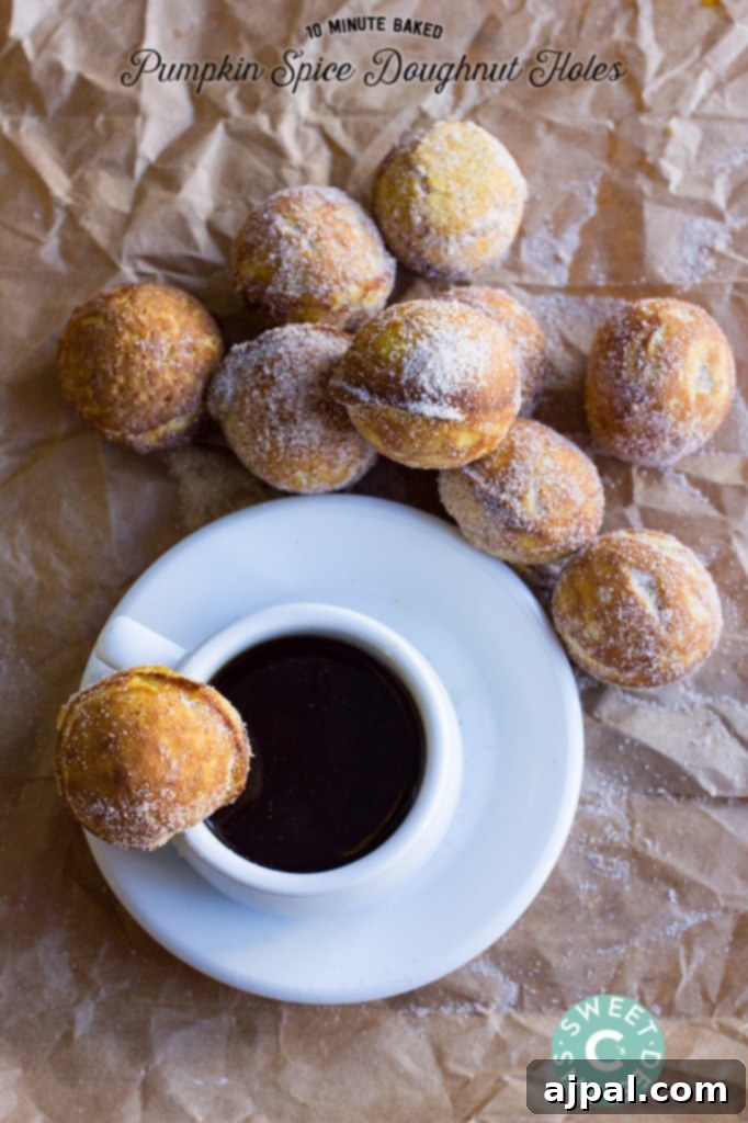 Close-up of baked pumpkin spice donut holes coated in cinnamon sugar, served alongside a cup of coffee.