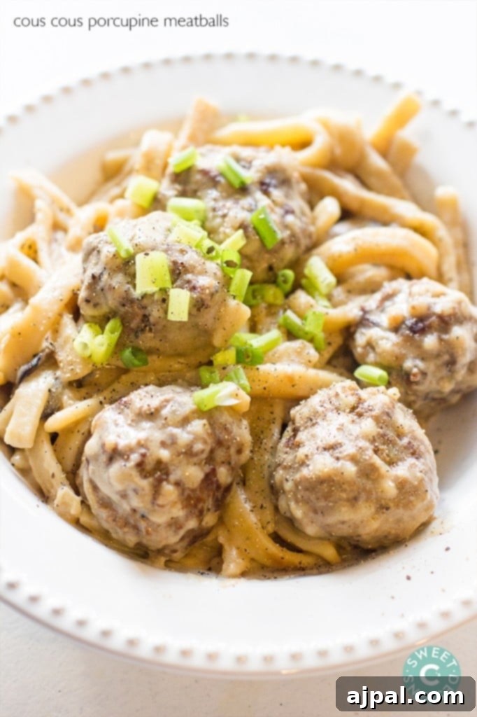 Spiky Couscous Meatballs 2 Delicious porcupine meatballs with a creamy sauce served over pasta, garnished with fresh herbs.
