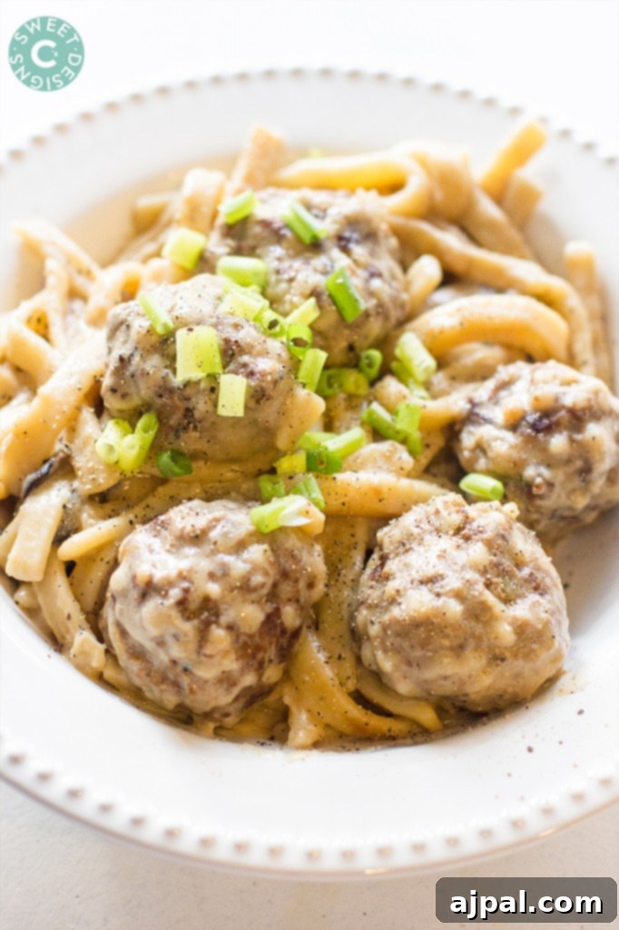 Spiky Couscous Meatballs 3 Hearty meatballs in a rich, creamy sauce, served elegantly on a white plate with fresh garnish.
