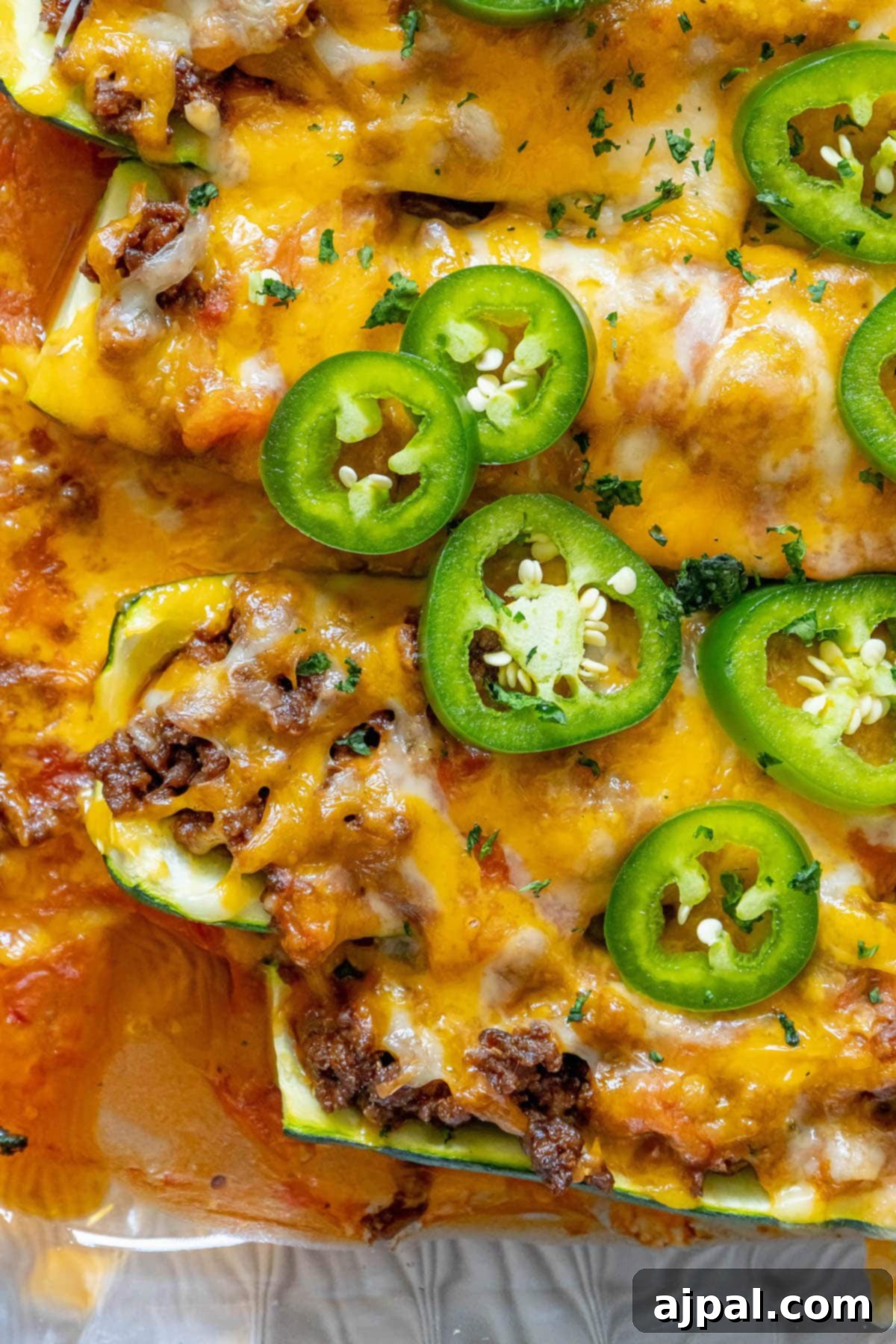 Baked Zucchini Treasures 2 Taco stuffed zucchinis baked in a glass dish with enchilada sauce and sliced jalapeños on top