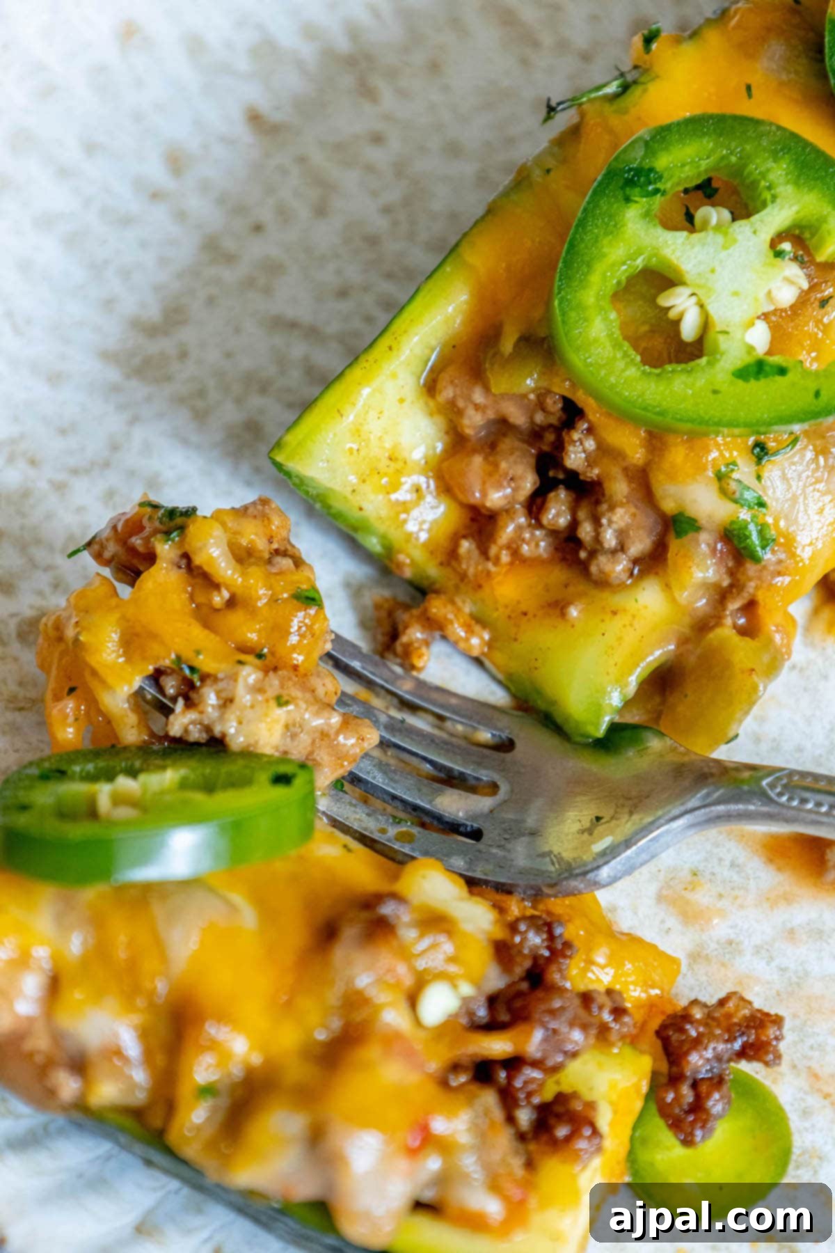 Baked Zucchini Treasures 12 A plate with a slice of zucchini topped with meat and peppers, resembling taco boats.