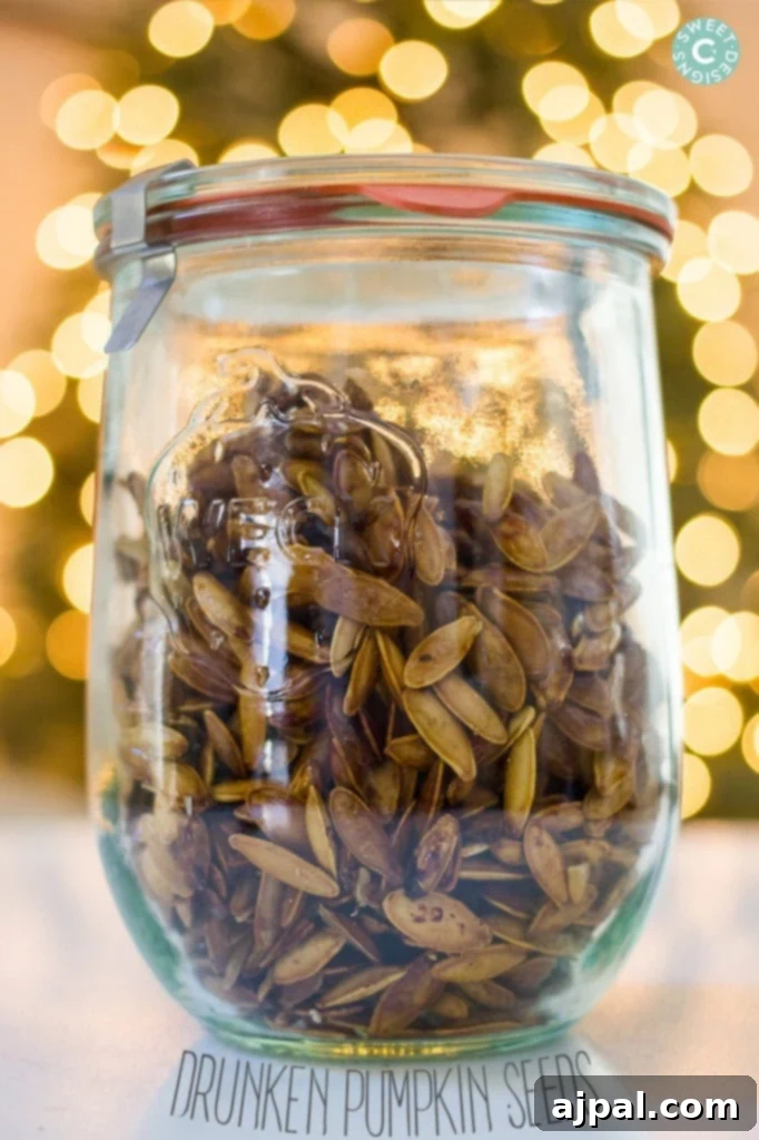 A glass jar filled with golden-brown whiskey-infused pumpkin seeds, ready for snacking or gifting.