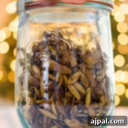 A glass jar filled with golden-brown whiskey-infused pumpkin seeds, ready for snacking or gifting.