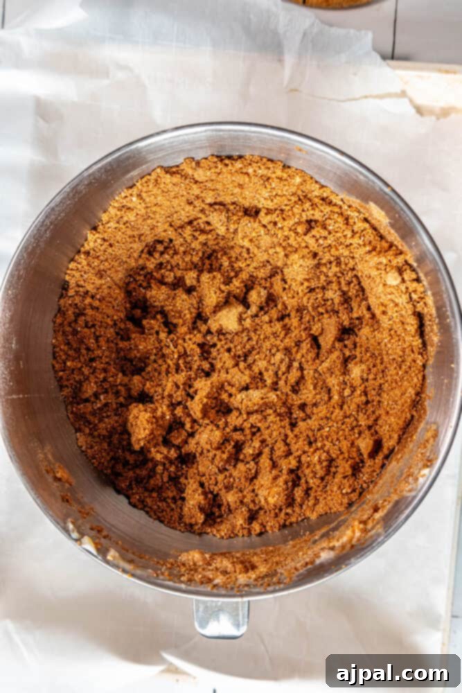 Spiced Molasses Chews 7 A metal mixing bowl with brown sugar, perfect for making soft molasses cookies.