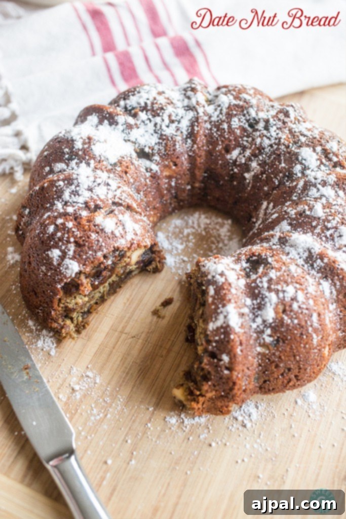Sweet Date Nut Loaf 2 Date Nut Bread - my grandma's secret recipe for the most delicious bread ever, dusted with powdered sugar on a cutting board.
