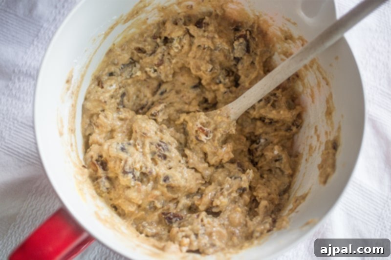 A bowl of Date Nut Bread batter with a wooden spoon.