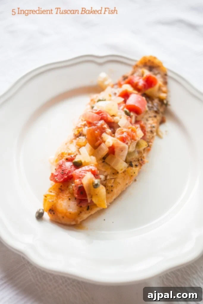 Flaky baked fish generously topped with capers and tomatoes, served with vibrant herbs.