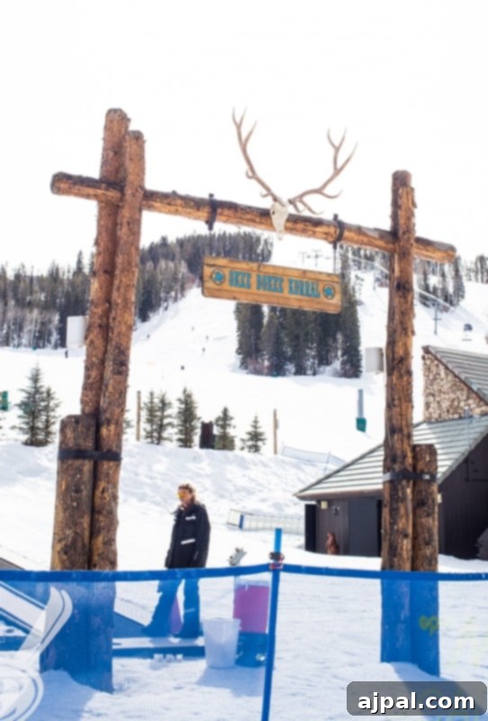 A happy young skier stands proudly in front of a rustic wooden sign at Beaver Creek Ski School.