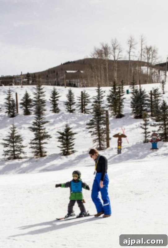 An adult and a child share a joyful moment on the slopes, highlighting the supportive atmosphere at Beaver Creek Ski School.