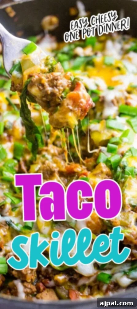 Loaded Cheesy Taco Skillet 15 picture of a fork lifting ground beef tacos with vegetables and cheese over a cheesy taco skillet in a pan