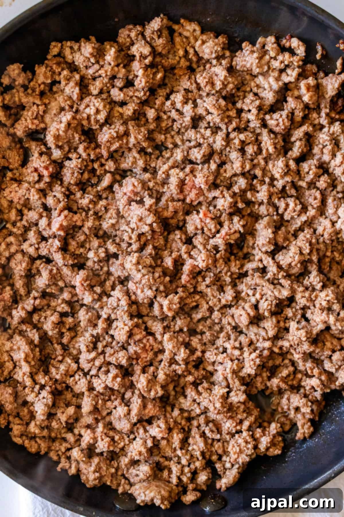 Loaded Cheesy Taco Skillet 4 Cooked ground beef in a black skillet, browned and crumbled into small pieces—perfect for creating The Best Taco Skillet.