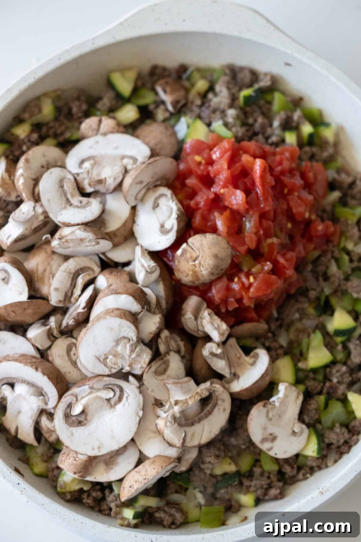 Loaded Cheesy Taco Skillet 7 A Cheesy Beef Taco Skillet filled with ground beef, chopped zucchini, uncooked sliced mushrooms, and diced tomatoes.