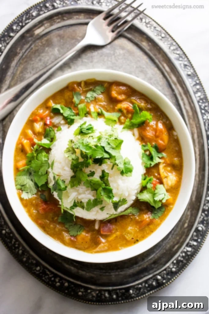 Smothered Langoustine 2 Luxurious Langoustine Étouffée served with fluffy white rice and fresh cilantro, embodying Cajun culinary excellence.