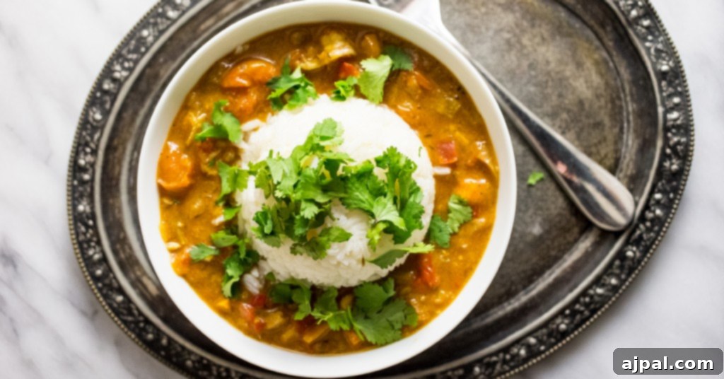 A beautiful serving of Langoustine Étouffée over rice, garnished with fresh cilantro, ready to be enjoyed as a classic Cajun meal.