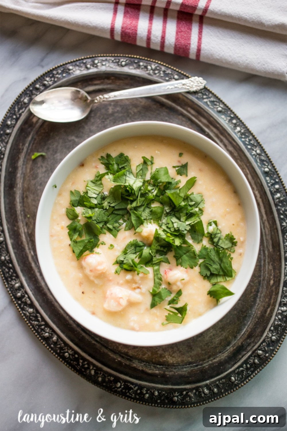 Gourmet Langoustine Grits 2 Creamy grits with generous chunks of succulent langoustine, artfully arranged in a pristine white bowl and garnished with fresh parsley.