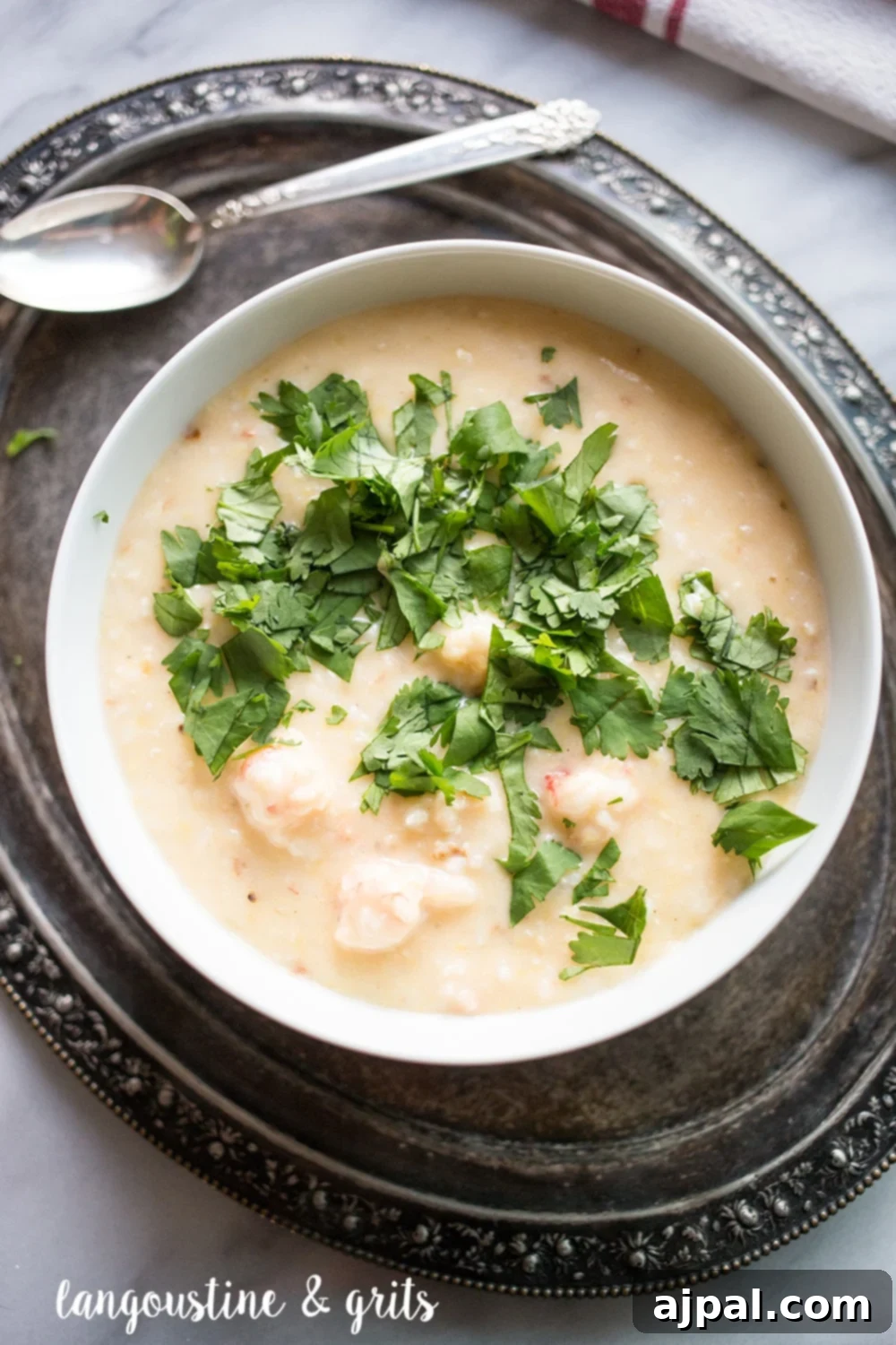 Gourmet Langoustine Grits 3 A beautifully presented bowl of creamy grits generously topped with succulent langoustine pieces and fresh parsley, perfect for a Southern-inspired meal.