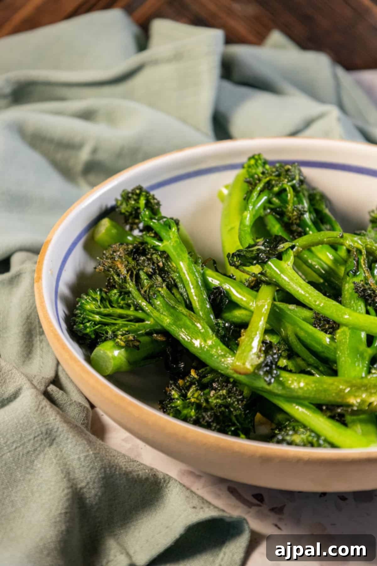 A bowl of vibrant green broccolini on a rustic table, ready to be enjoyed.