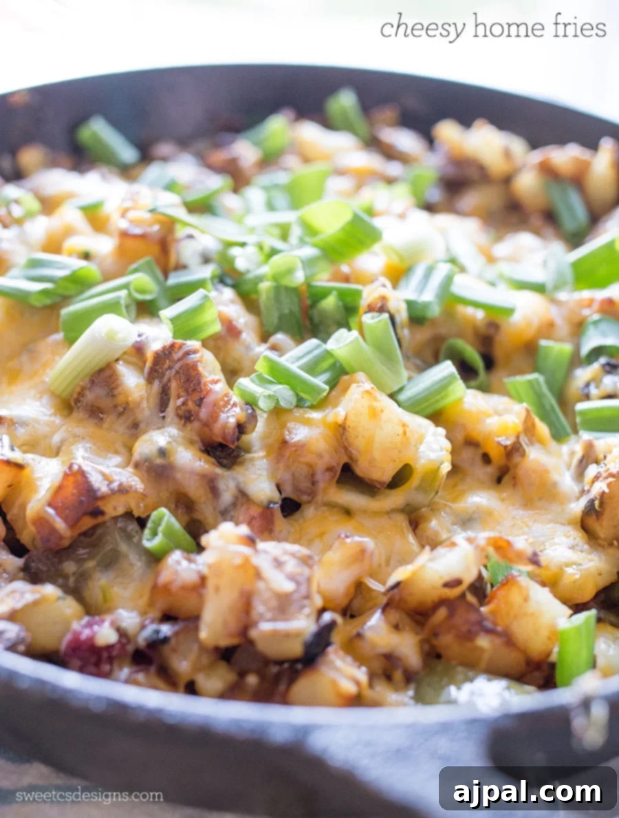 Close-up of golden Cheesy Veggie Home Fries in a skillet, ready to serve.