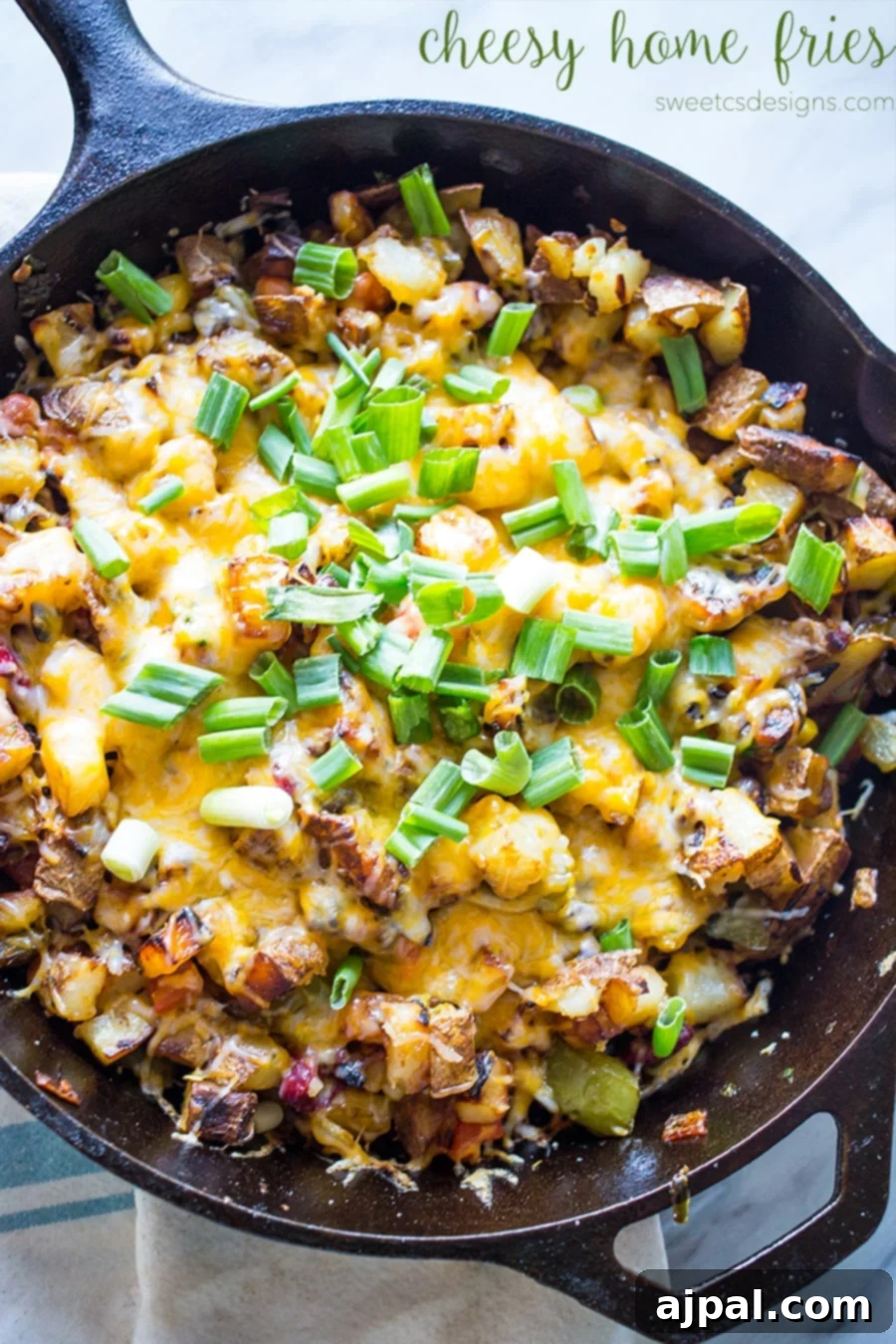 Large serving of Cheesy Veggie Home Fries in a cast iron skillet, garnished with green onions.