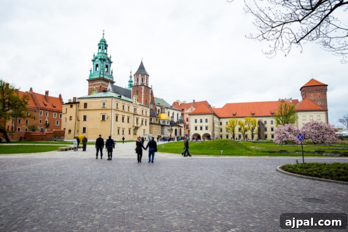 Discovering Krakow's Wawel Castle and Cathedral 3 Visitors exploring the grand courtyard of Wawel Castle in Krakow, with the historic Cathedral in the background