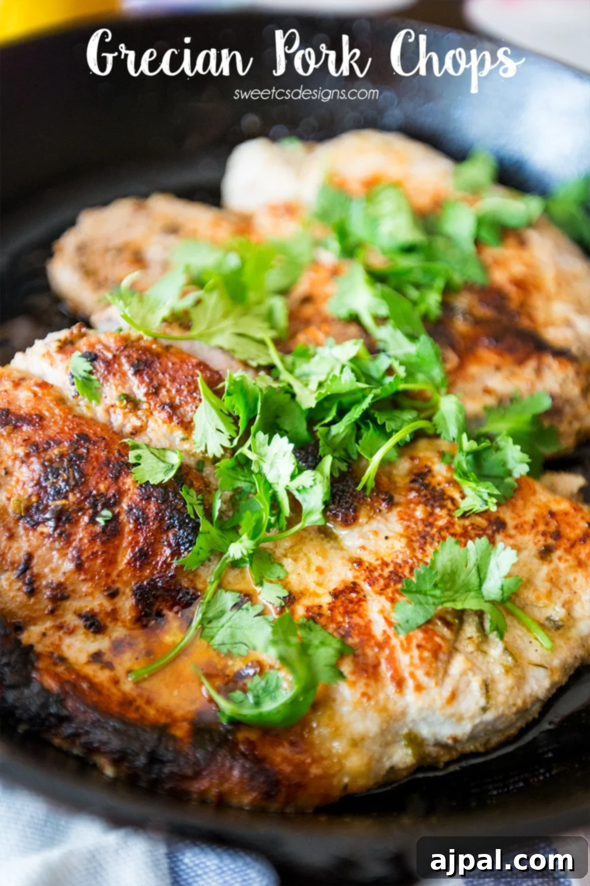 Lemon Garlic Greek Pork Chops 2 Perfectly cooked Grecian pork chops, garnished with fresh cilantro, ready to serve.