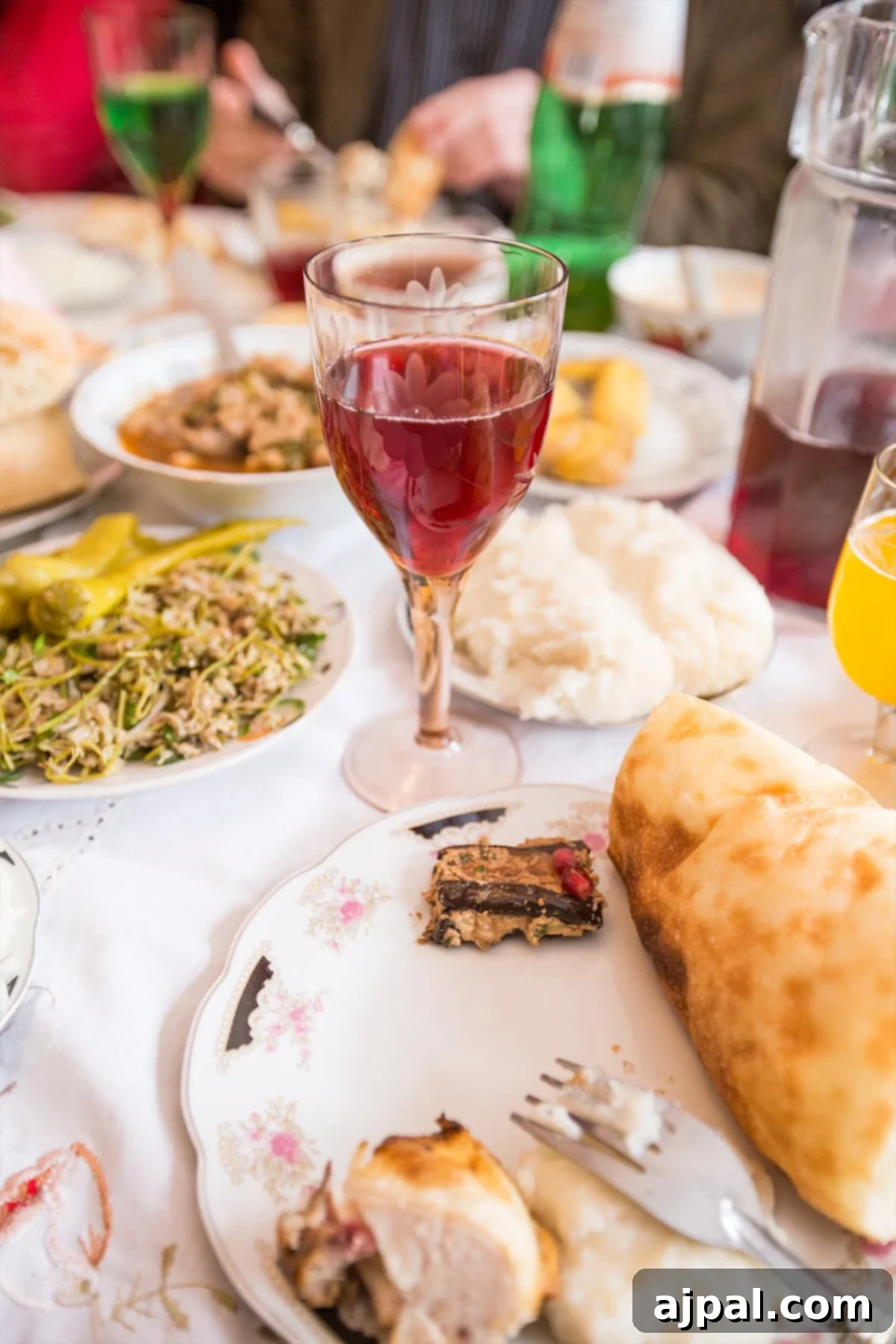 Georgian Supra: A Toast to Wine and Tradition 6 A wine glass surrounded by an abundant spread of traditional Georgian food, showcasing the rich culinary offerings of a Supra