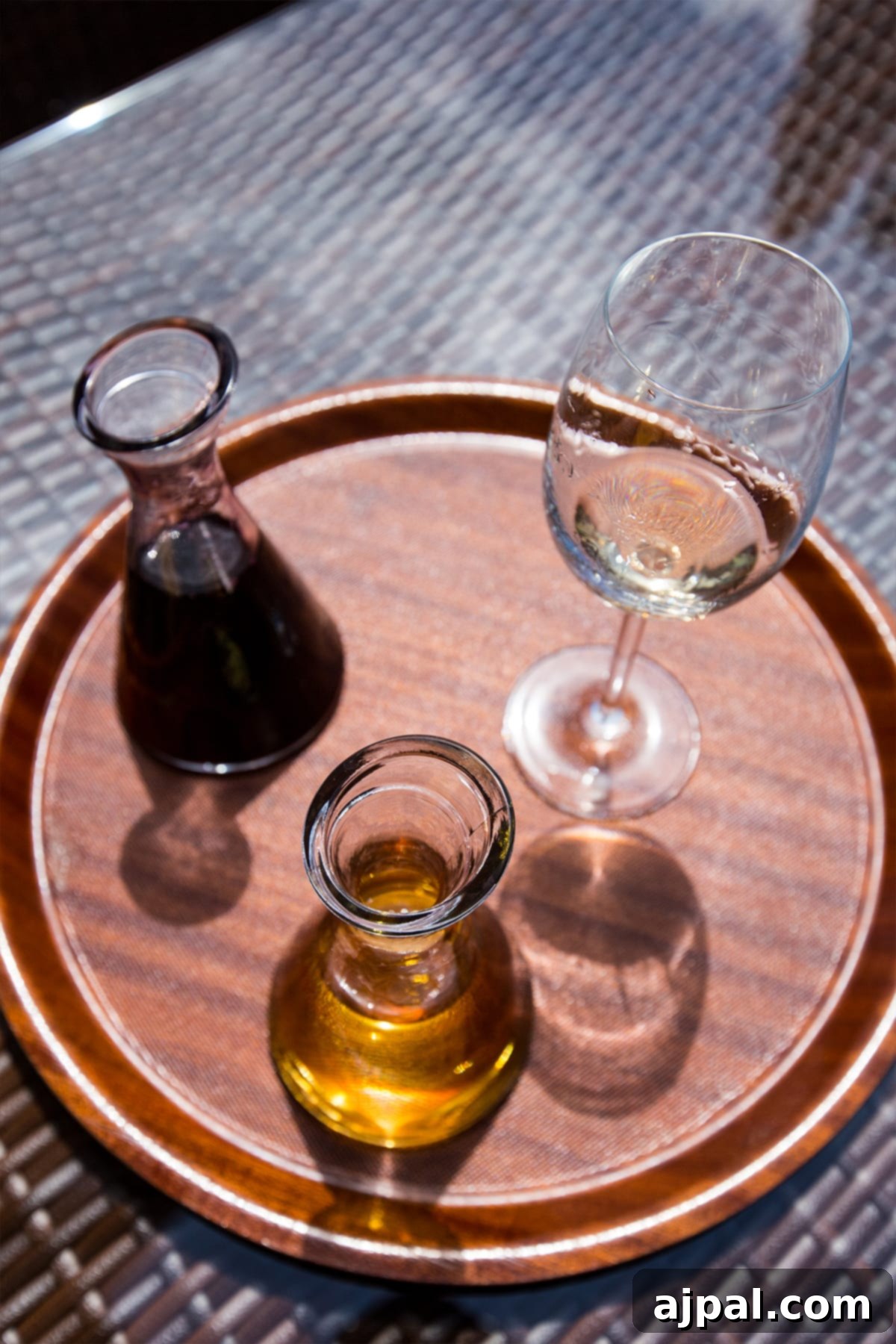 A glass of Georgian wine and a decanter on a wooden tray