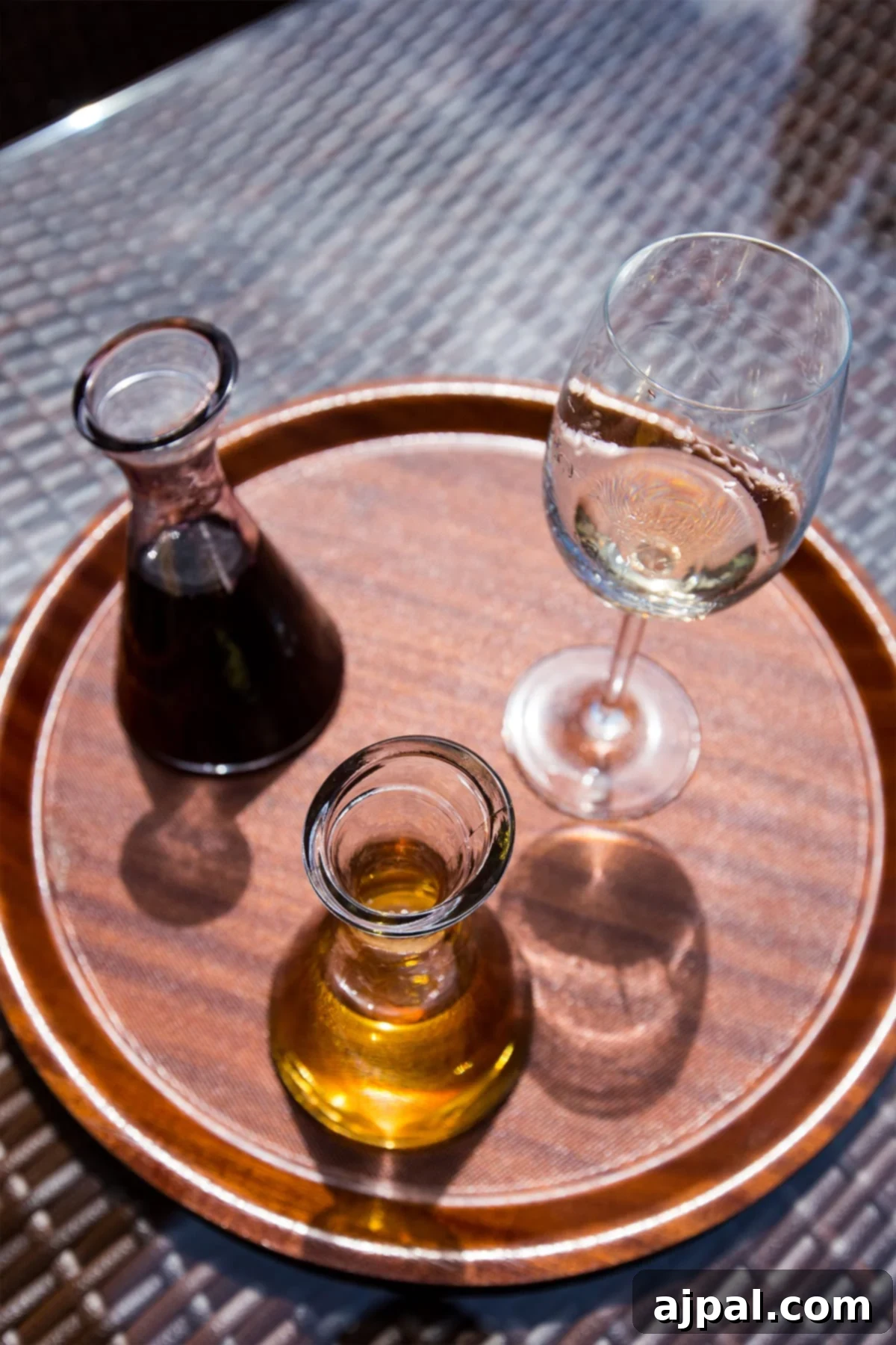 Georgian Supra: A Toast to Wine and Tradition 7 A wooden tray featuring a elegant glass of Georgian wine and a bottle of olive oil, symbolizing the rich culinary and viticultural traditions