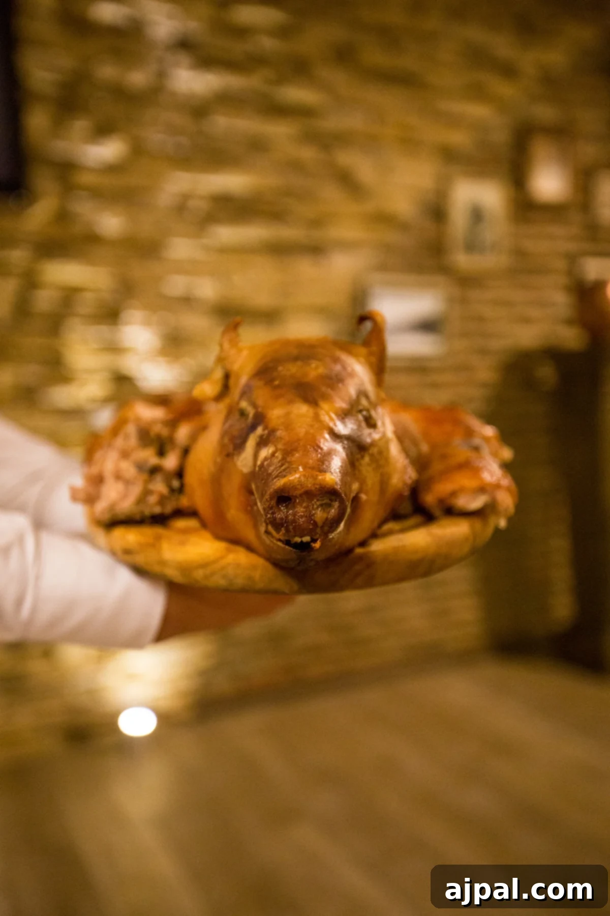 Georgian Supra: A Toast to Wine and Tradition 9 A man proudly presenting a roasted pig on a wooden platter during a Georgian Supra, highlighting a celebratory dish