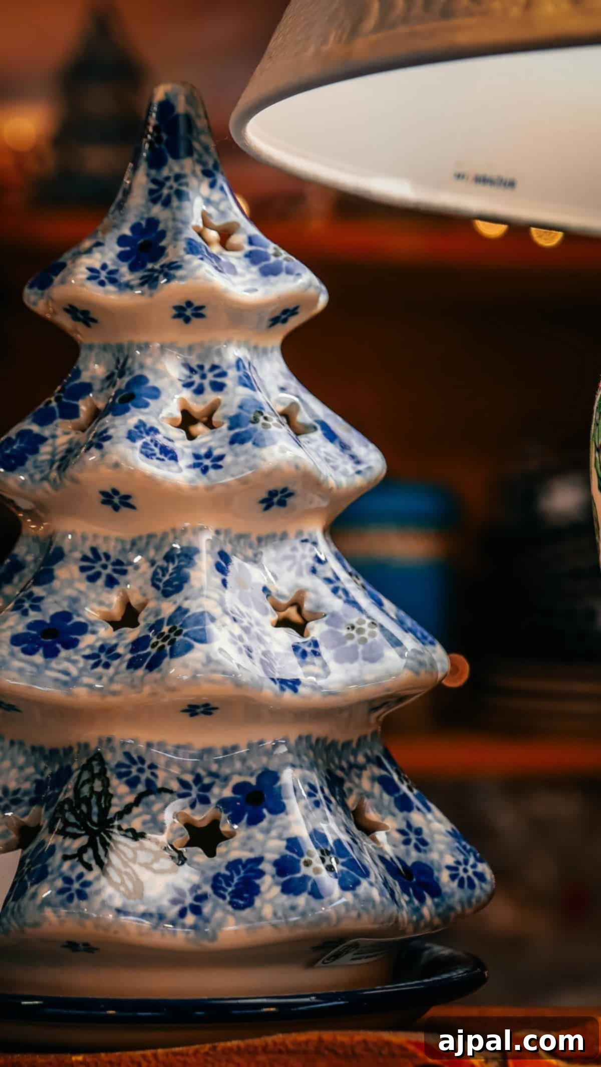 Krakow: Poland's Royal City 24 A ceramic Christmas tree with blue floral patterns and star cutouts, illuminated by a lamp.