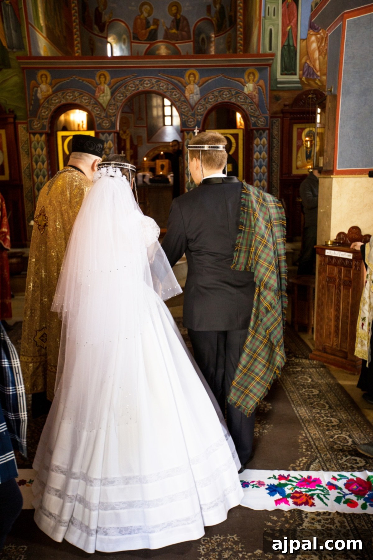 A bride and groom walking down the aisle during a traditional Orthodox wedding in Lurji Monastery, Tbilisi