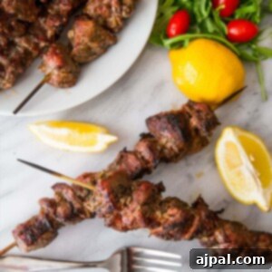 souvlaki skewers on a table with lemon wedges