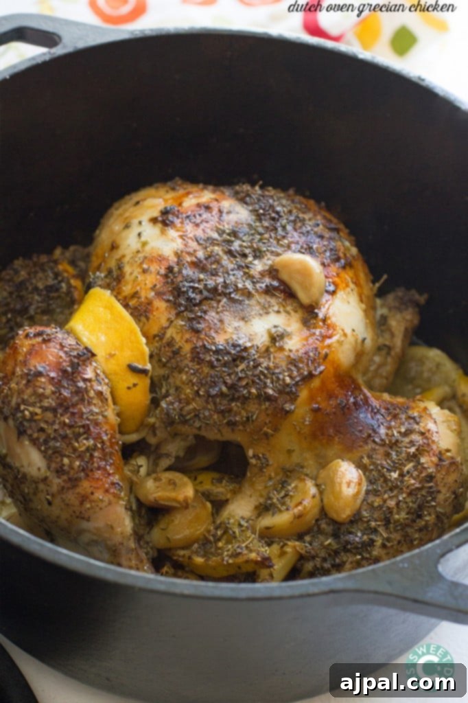 A whole roasted Greek chicken glistening with lemon and garlic, served in a cast iron skillet.