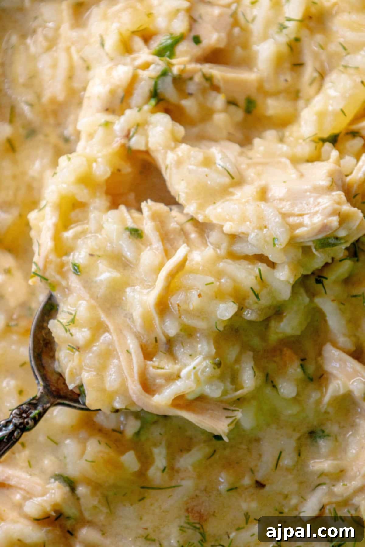 A spoonful of avgolemono chicken risotto in a skillet.
