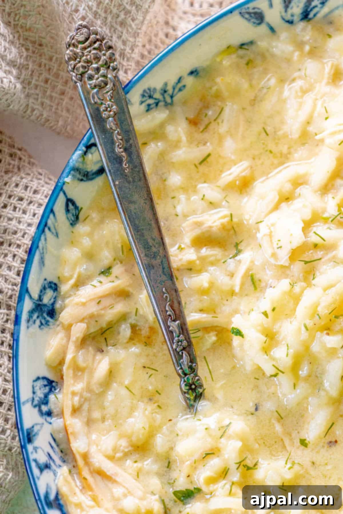 Greek chicken risotto in a blue and white bowl with a spoon.