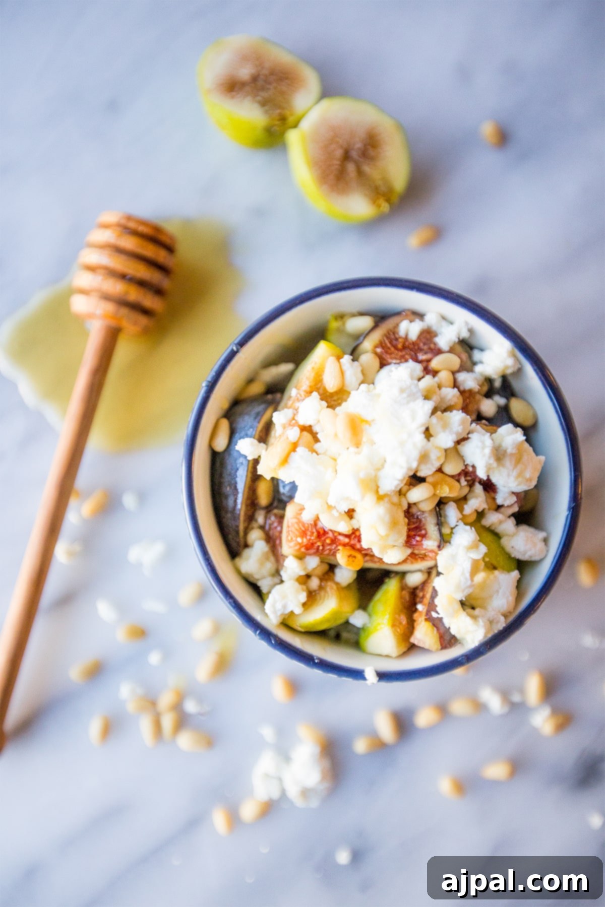 Close-up of a Fig and Honey Fruit Salad, highlighting the textures of figs, cheese, and pine nuts.