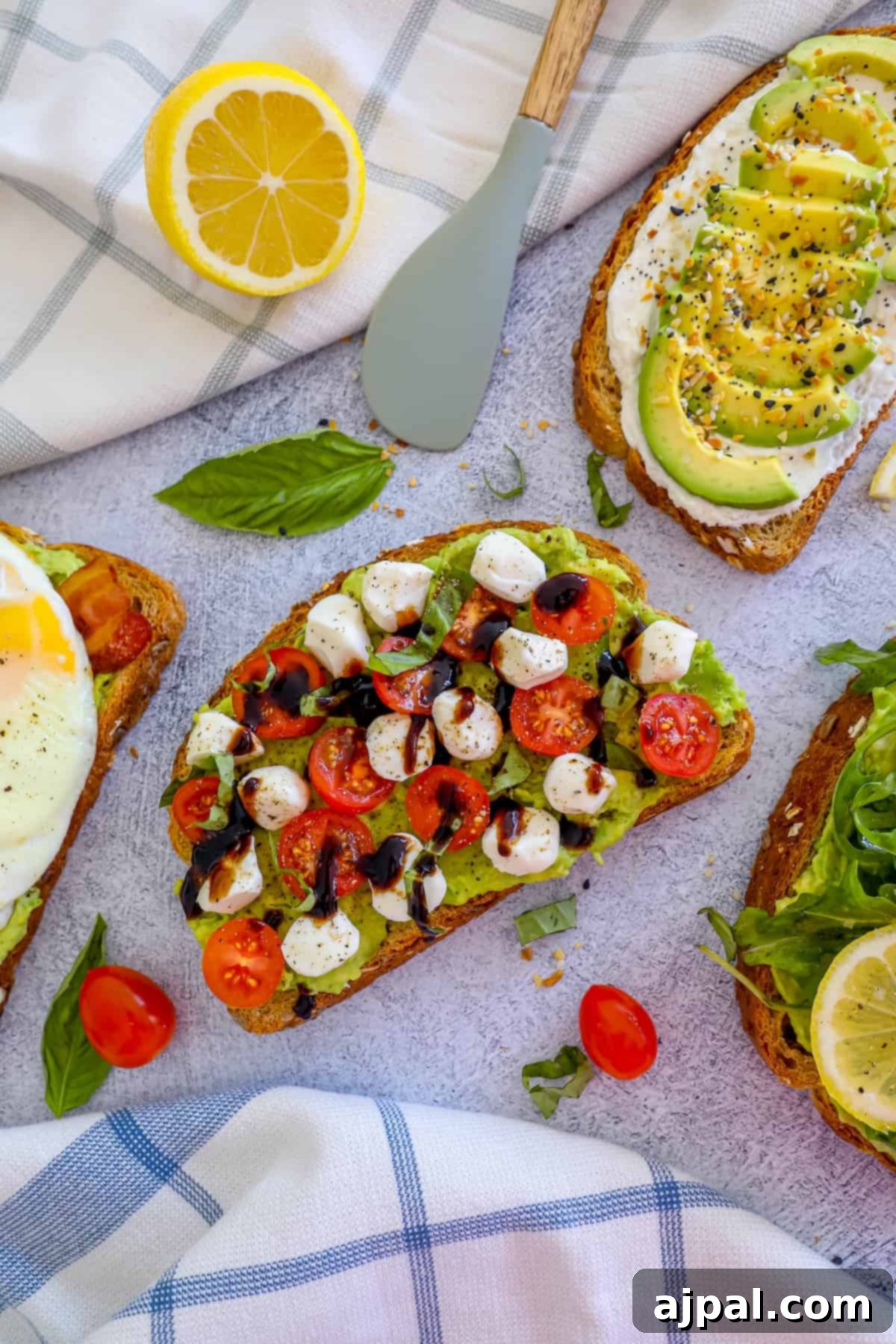 Smashed Avocado Toast 6 Four delicious avocado toasts garnished with fresh tomatoes, lemon wedges, and a fried egg, artfully arranged on a serving platter.