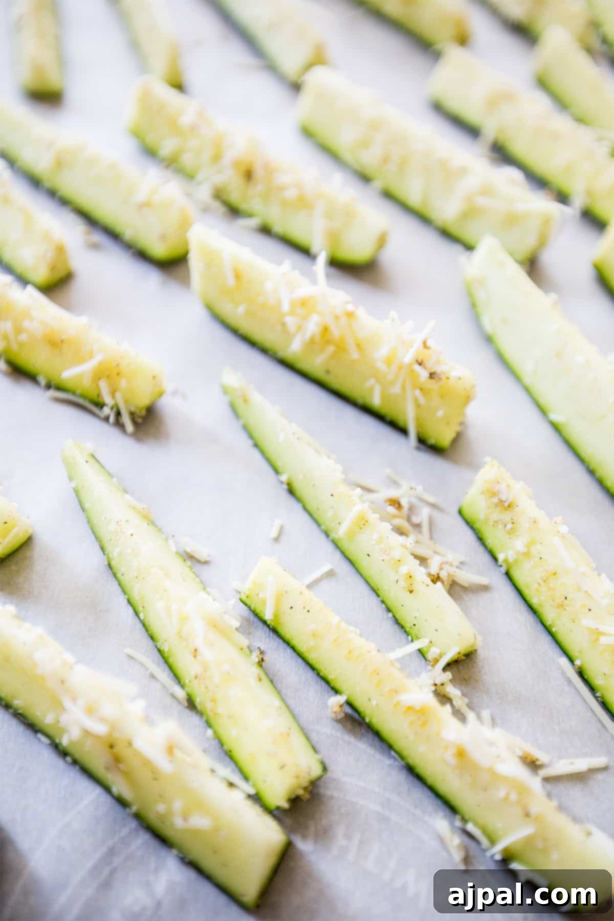 Keto Garlic Parm Zucchini Fries 5 Seasoned zucchini sticks with Parmesan and garlic, freshly baked on a sheet pan