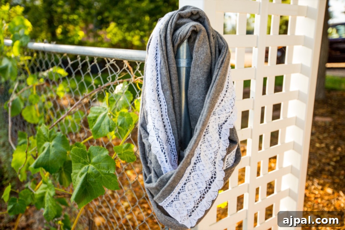 Whip Up a Lace Infinity Scarf in 15 Minutes 11 A beautifully finished lace embellished infinity scarf, gracefully draped and showcased against a blurred background, highlighting its soft fabric and elegant design.