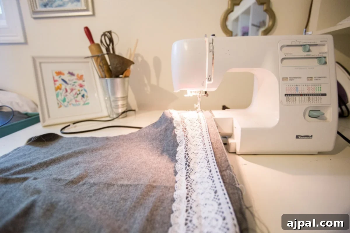Whip Up a Lace Infinity Scarf in 15 Minutes 5 A sewing machine adding a delicate lace trim to the edge of a cotton fabric, demonstrating how to embellish an infinity scarf with a simple straight stitch.