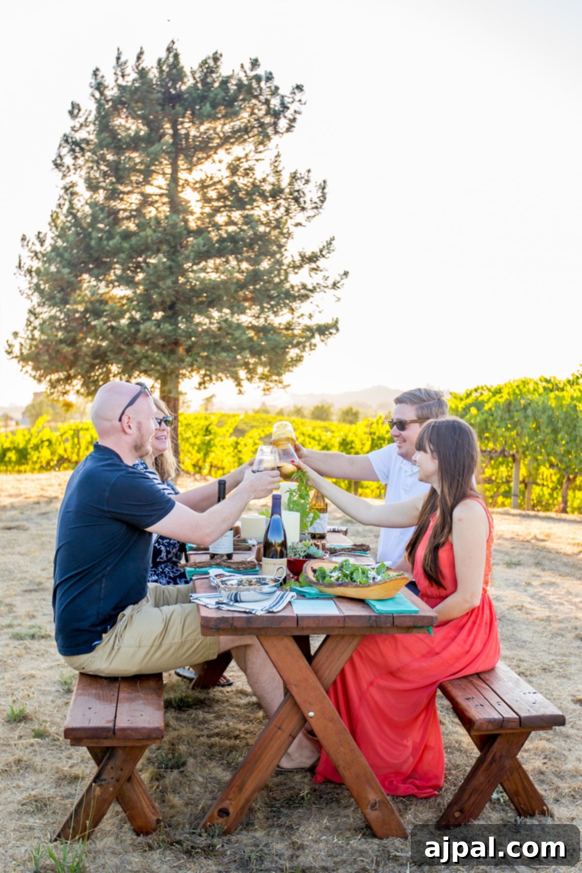 Four people toasting at a fall harvest picnic table with succulent centerpieces in a field