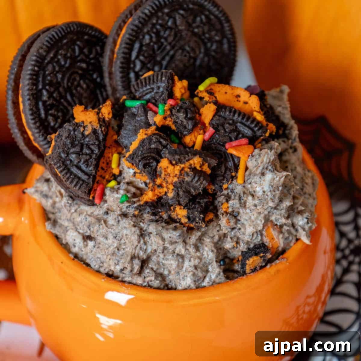 Spooktacular Halloween Treats You Need to Try 12 Halloween oreo milkshake in a mug with pumpkins and oreos.