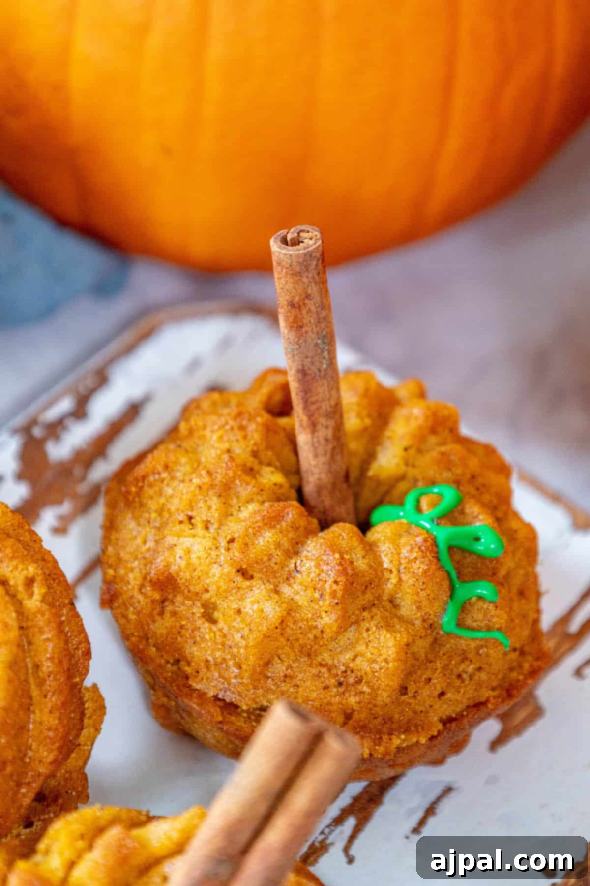 Spooktacular Halloween Treats You Need to Try 23 Halloween pumpkin muffins with cinnamon sticks on a plate.