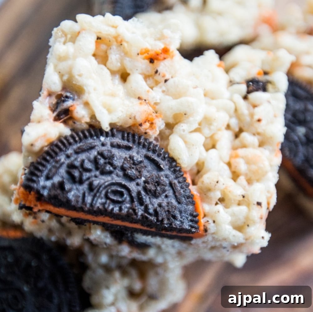 Spooktacular Halloween Treats You Need to Try 24 Halloween-themed Oreo Krispie Treats on a cutting board.